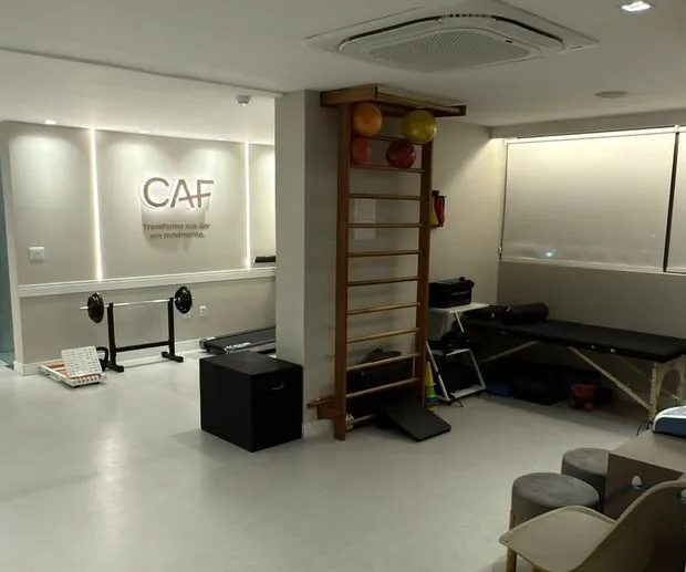 Sala de atendimento com espaldar, maca e equipamentos de reabilitação